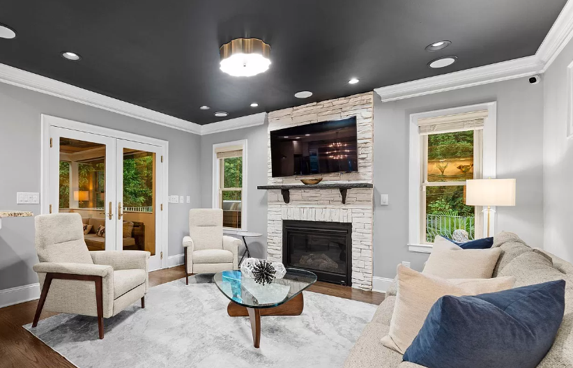 Living room with fireplace, white brick, gray walls, black ceiling, and furniture.