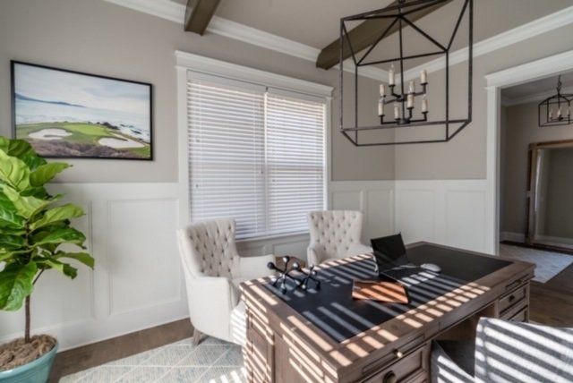 Office with a desk, two chairs, window, and a large geometric light fixture. 