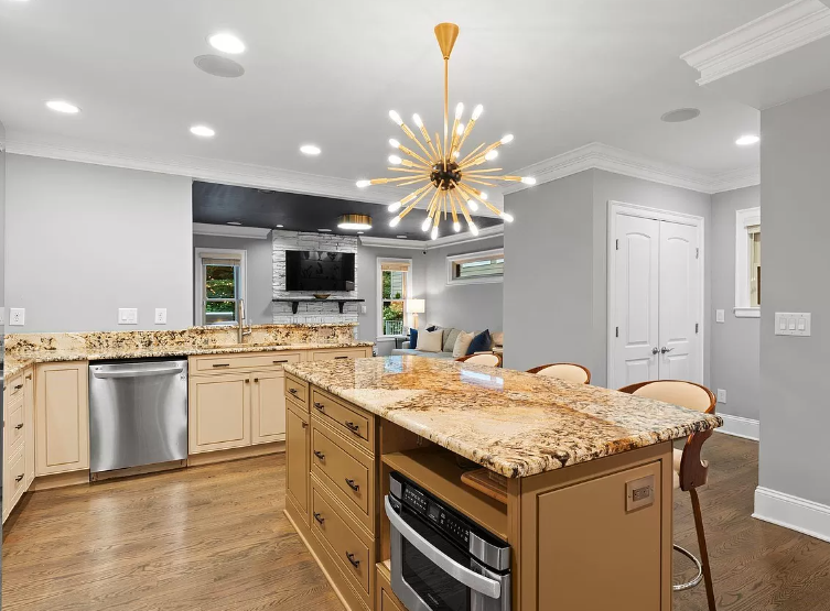 Spacious kitchen with a large island, granite countertops, and a starburst light fixture.
