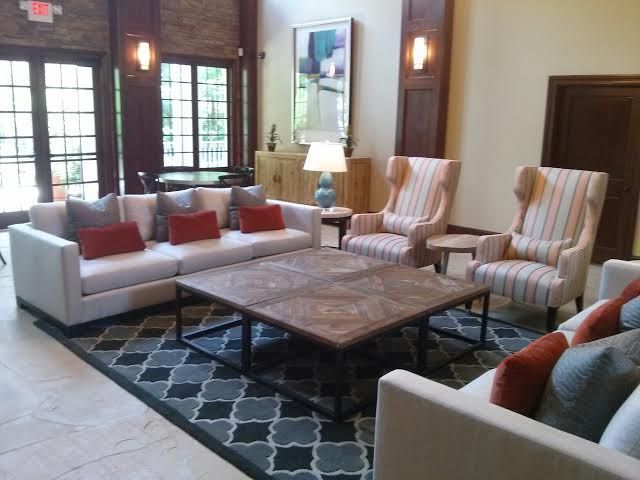 Lounge area with two sofas, two armchairs, and a coffee table on a patterned rug.