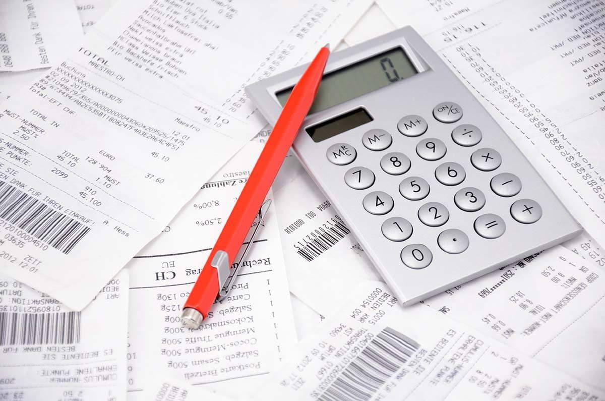 A calculator is sitting on top of a pile of receipts