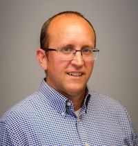 A woman with gray hair is smiling for the camera.