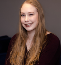 A woman with long blonde hair is smiling for the camera.
