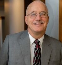 A man in a suit and tie is smiling for the camera.