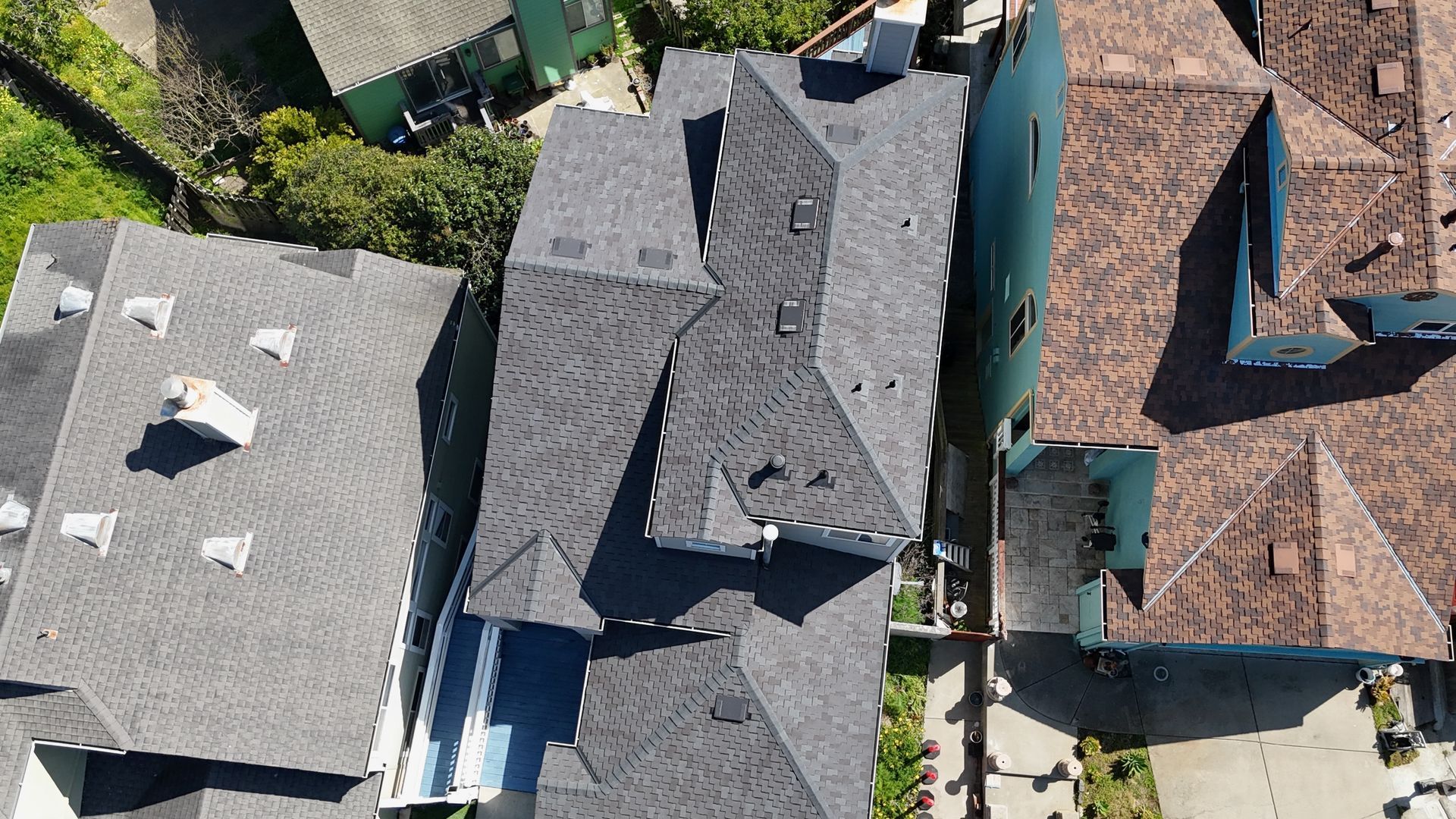 Overhead view of several houses with dark gray roofs.