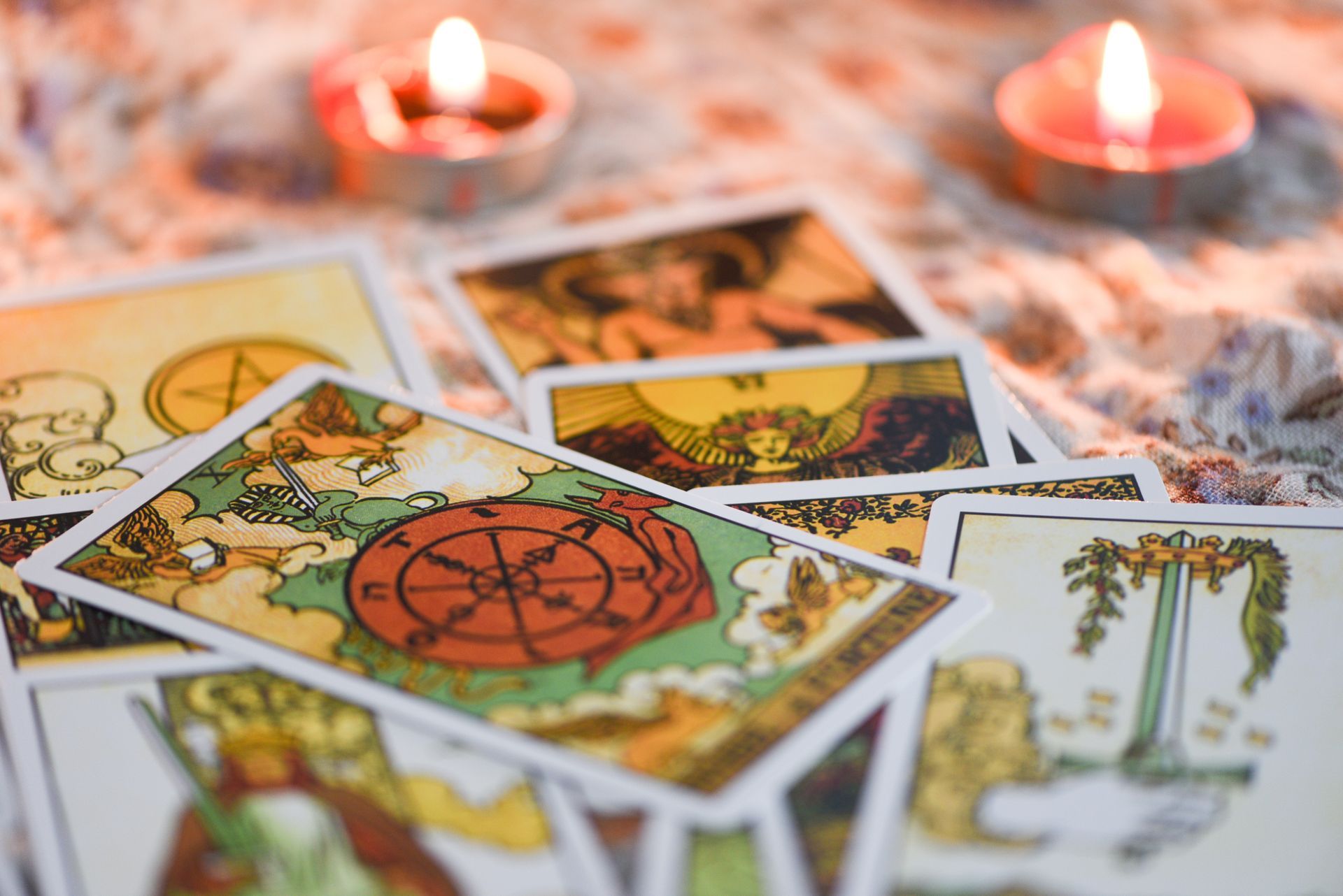 Tarot cards spread out with lit candles in the background.