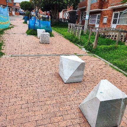 Una fila de bloques de hormigón se encuentran sobre una acera de ladrillos.