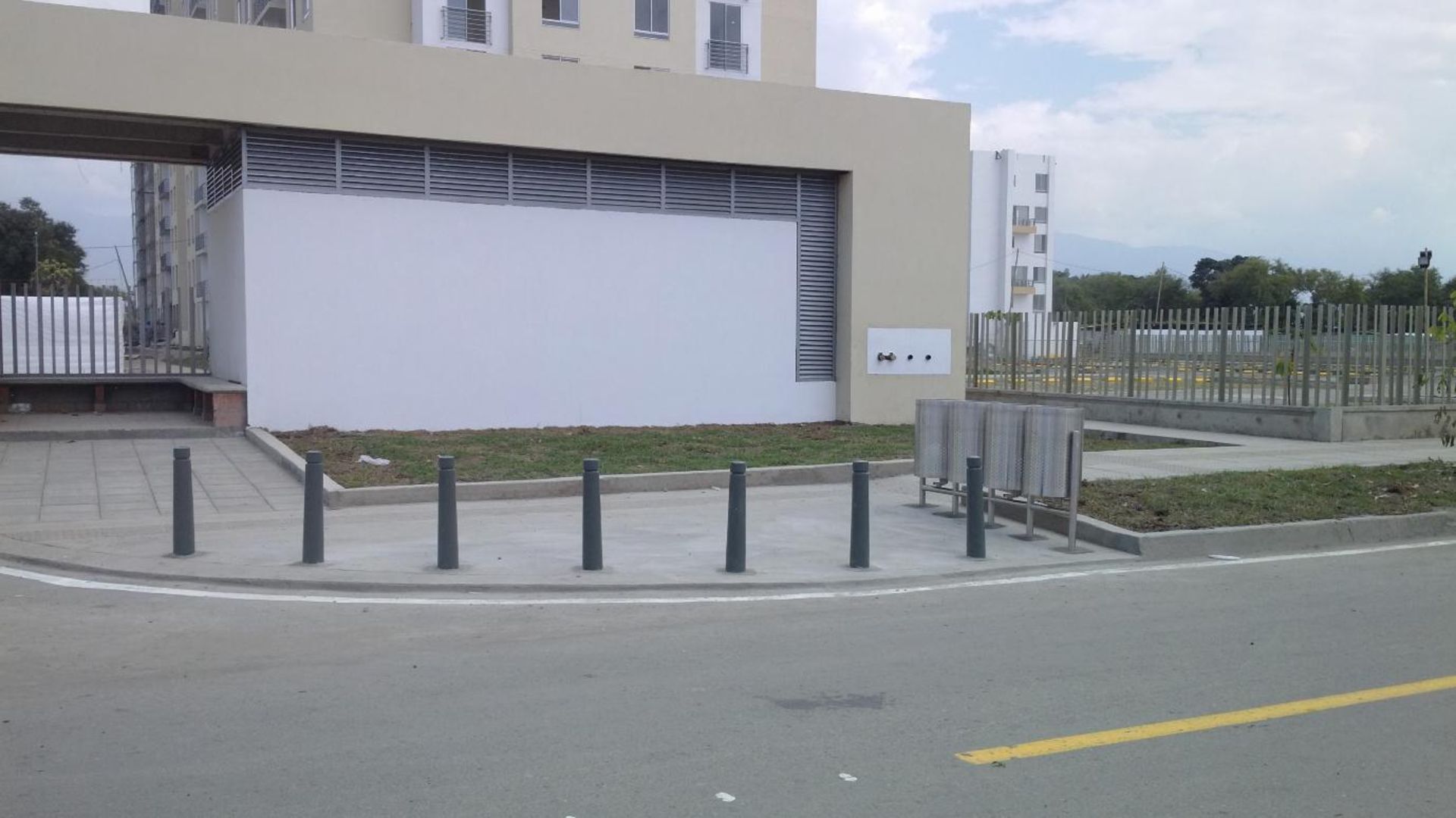 Un edificio con muchas ventanas está al lado de una carretera.