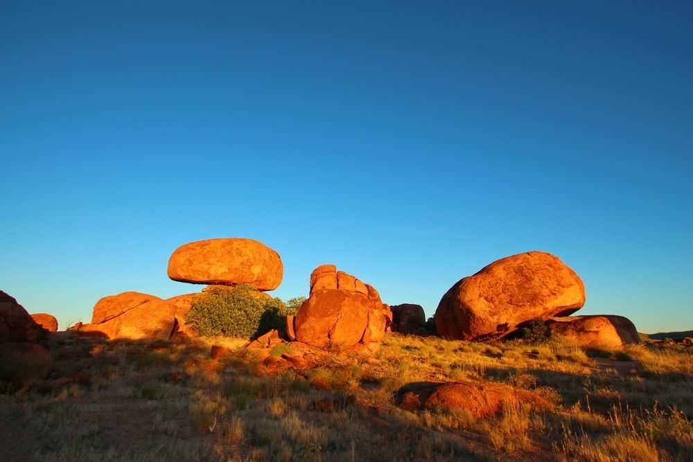 A Group Of Rocks In A Field With A Blue Sky In The Background — PK Crash Repairs In Tennant Creek, NT