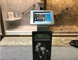 Tablet display showing a bathroom with handrails, atop a stand with a