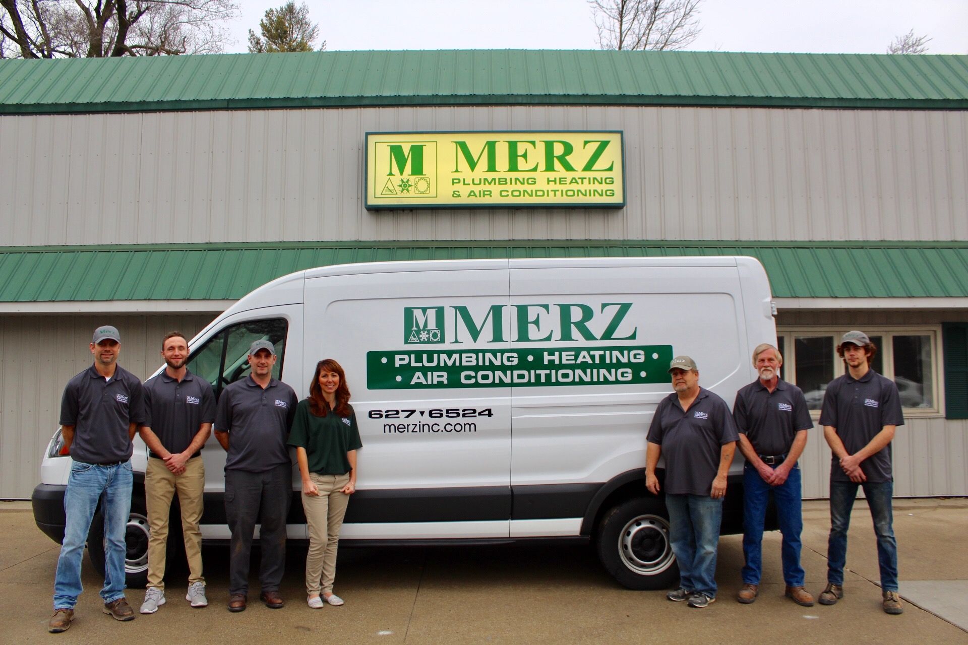 A group of people standing in front of a merz van