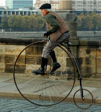 Elderly man rides Penny Farthing