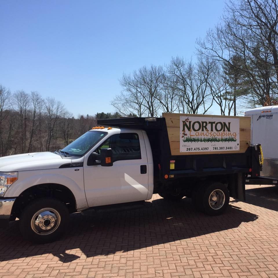 White truck with black bed and wood side panel. 