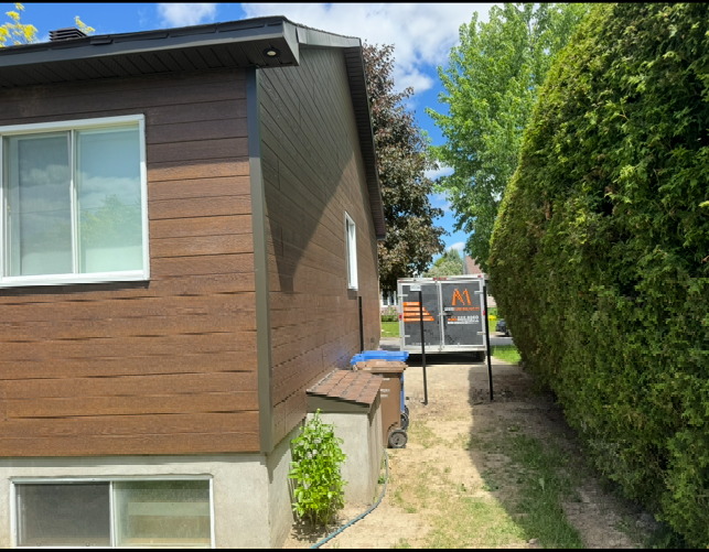 Une maison avec un camion garé devant.