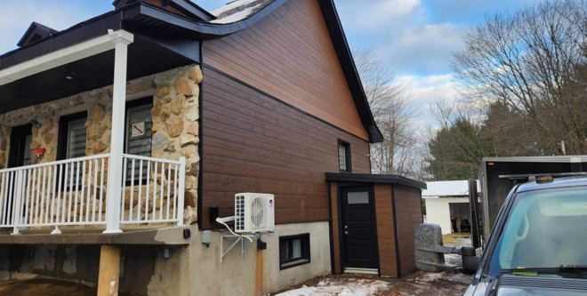 Une maison avec une voiture garée devant.