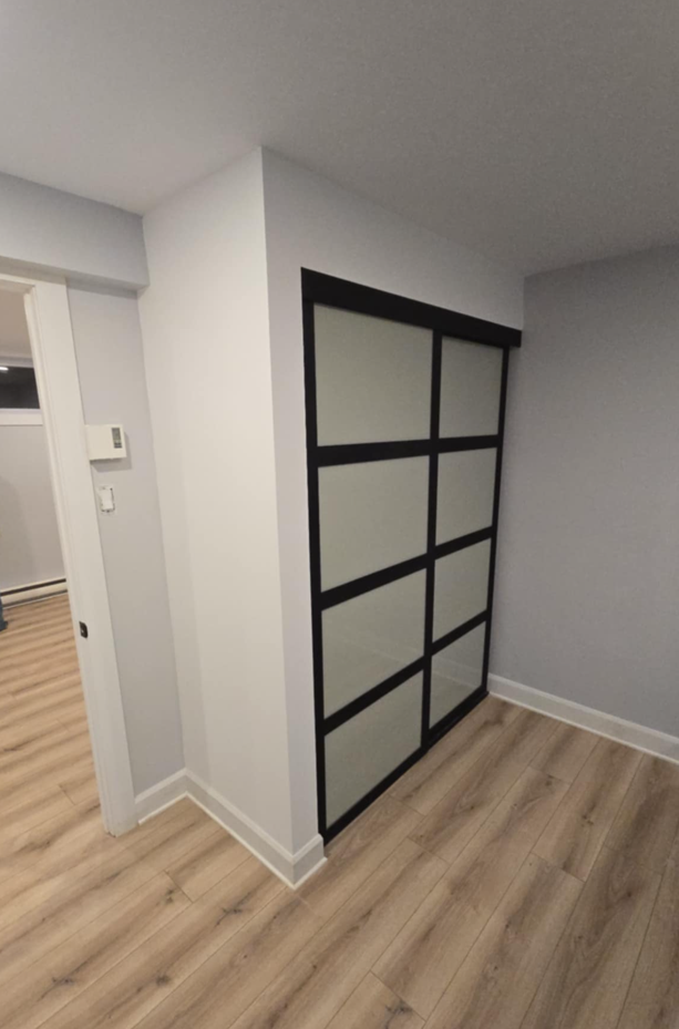 Il y a une porte coulissante en verre dans le coin de la pièce.