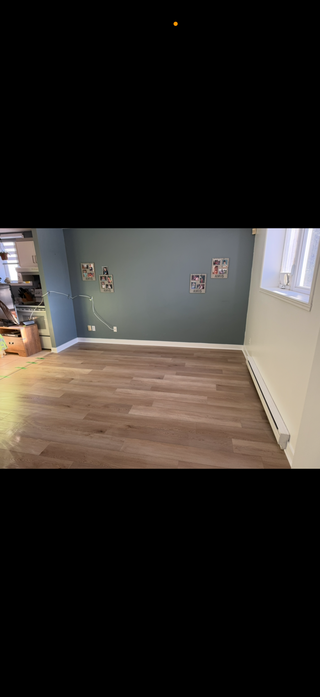 Une pièce avec un plancher en bois et un mur bleu.