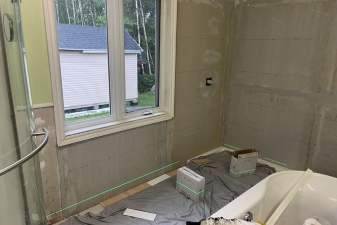 Une salle de bain en construction avec une baignoire et une fenêtre.