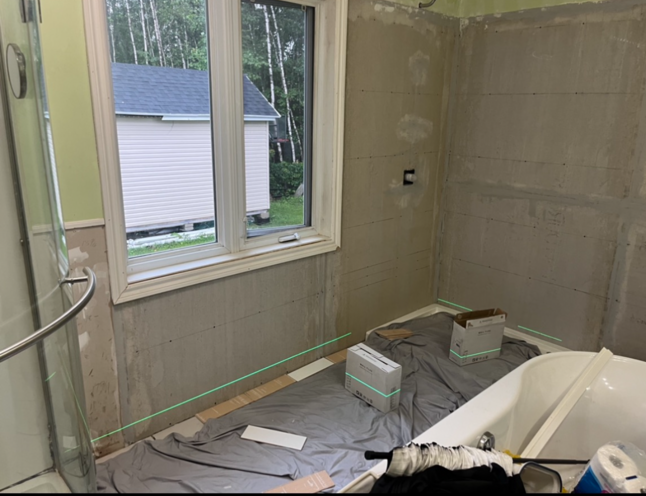 Une salle de bain en construction avec une baignoire et une fenêtre.