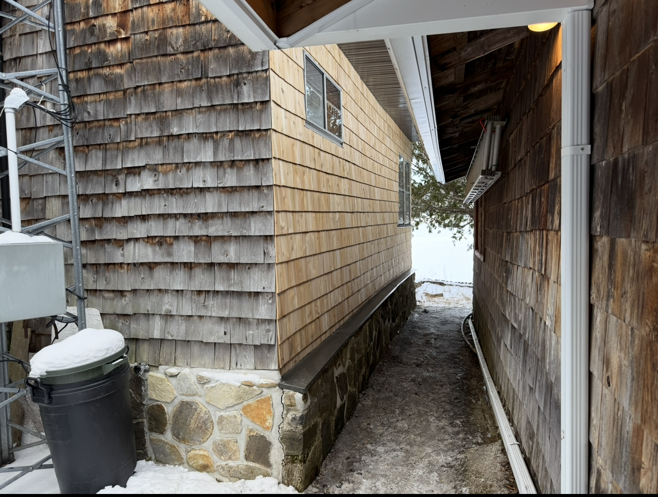 Une ruelle étroite entre deux bâtiments avec de la neige au sol