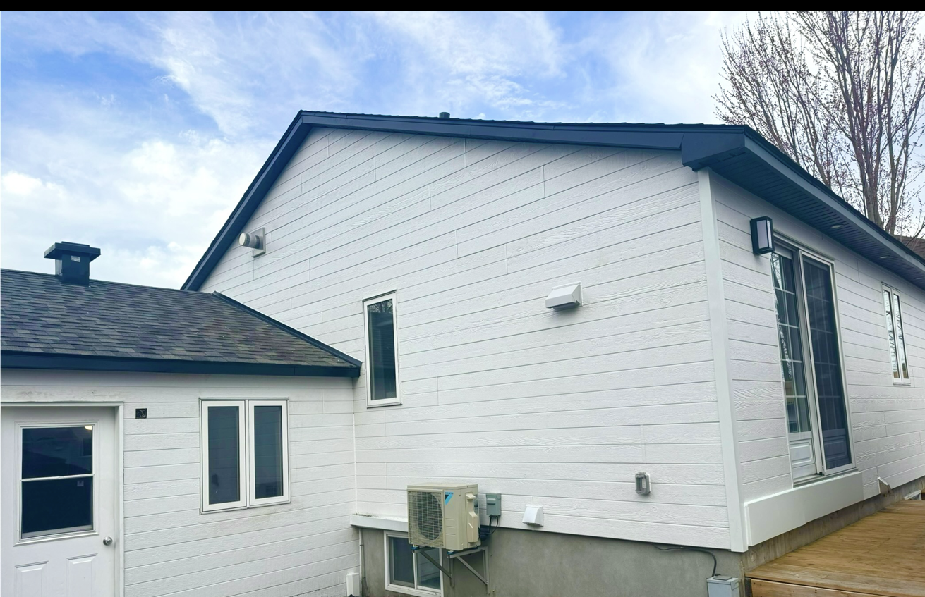 L'arrière d'une maison blanche avec un toit noir