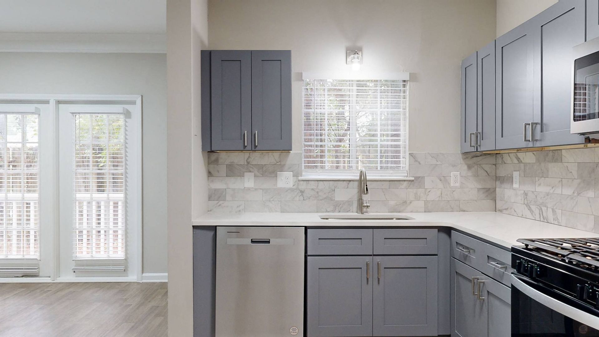 Renovated kitchen with grey cabinetry, stainless appliances