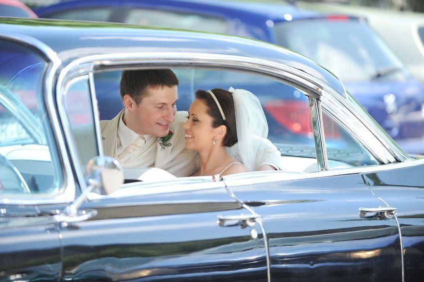 a newly married couple sitting in the car