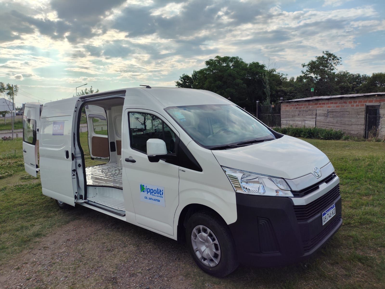 Furgoneta Toyota de color blanco, con puerta lateral abierta, estacionada al aire libre.