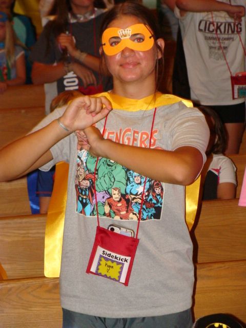 Person wearing a mask, cape, and Avengers shirt, posing as a superhero.