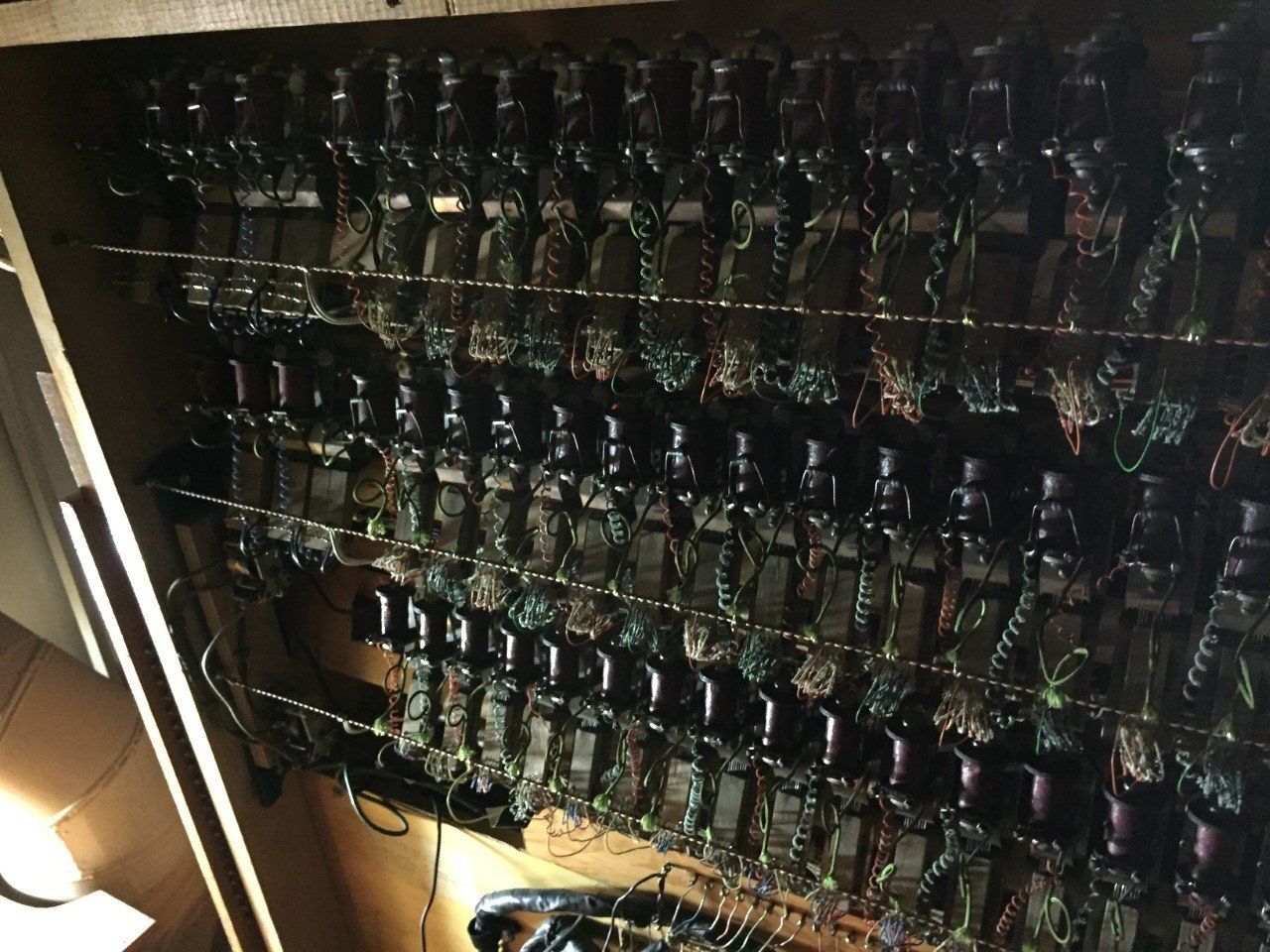 Inside of an old telephone switchboard, showing numerous relays and wiring.