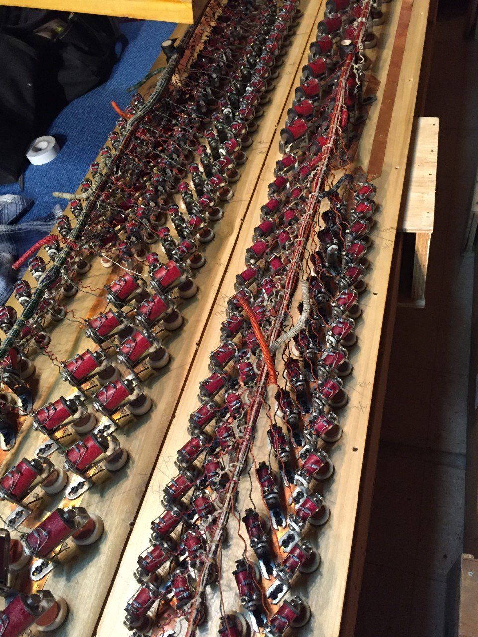 Rows of red electronic components and wires on wooden boards.