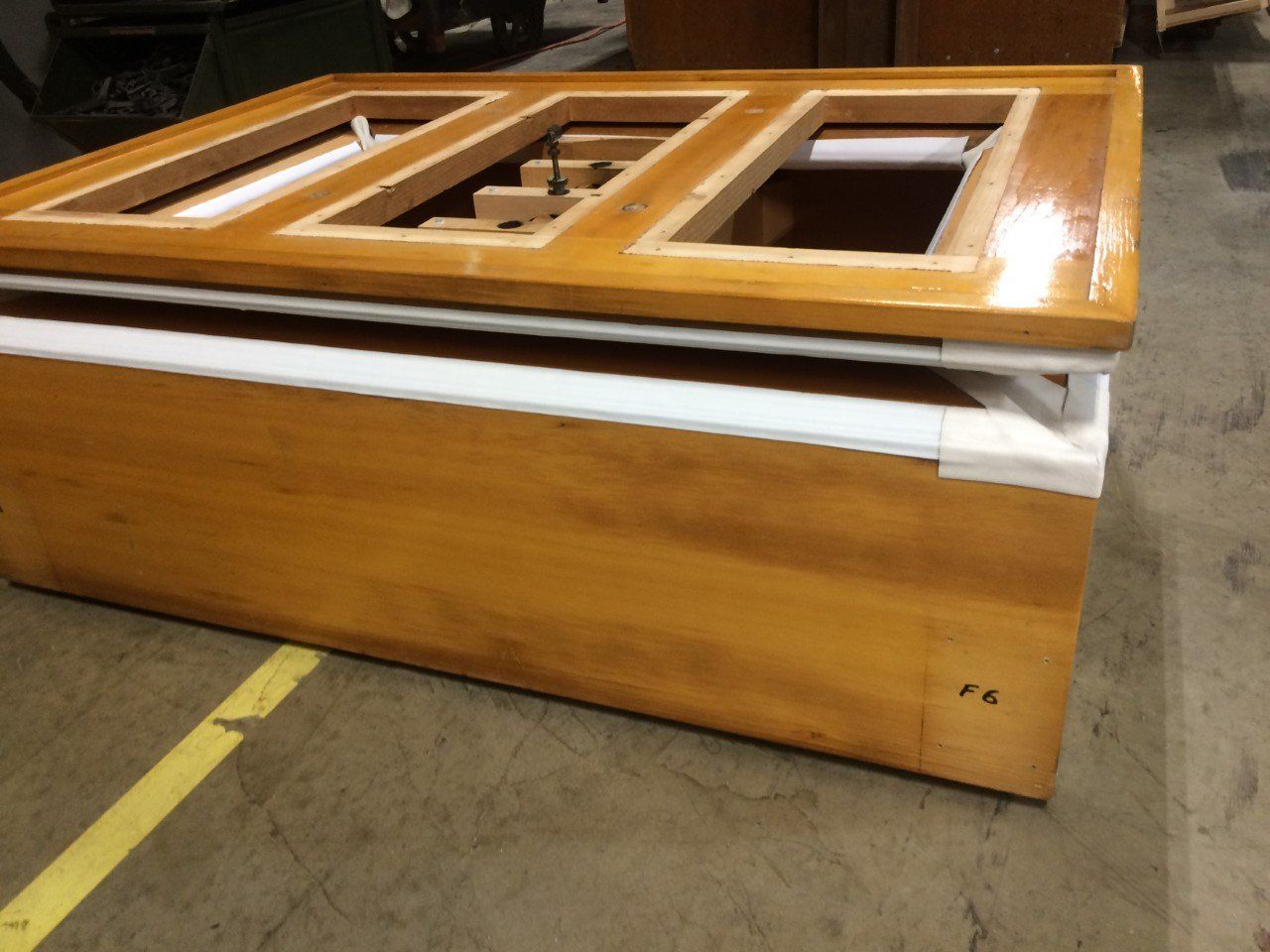 Wooden box with a glossy, lighter wood top and rectangular openings, white trim, and natural wood sides.