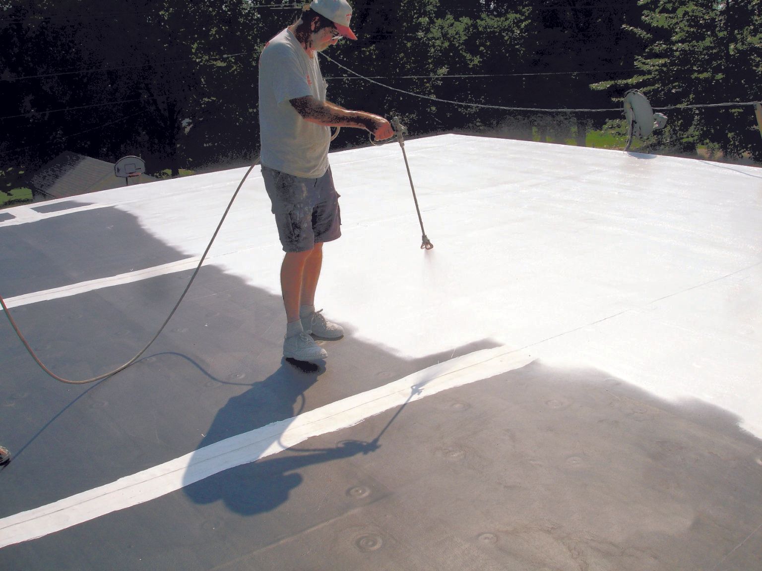 a man spraying Membrane Coating System on the roof