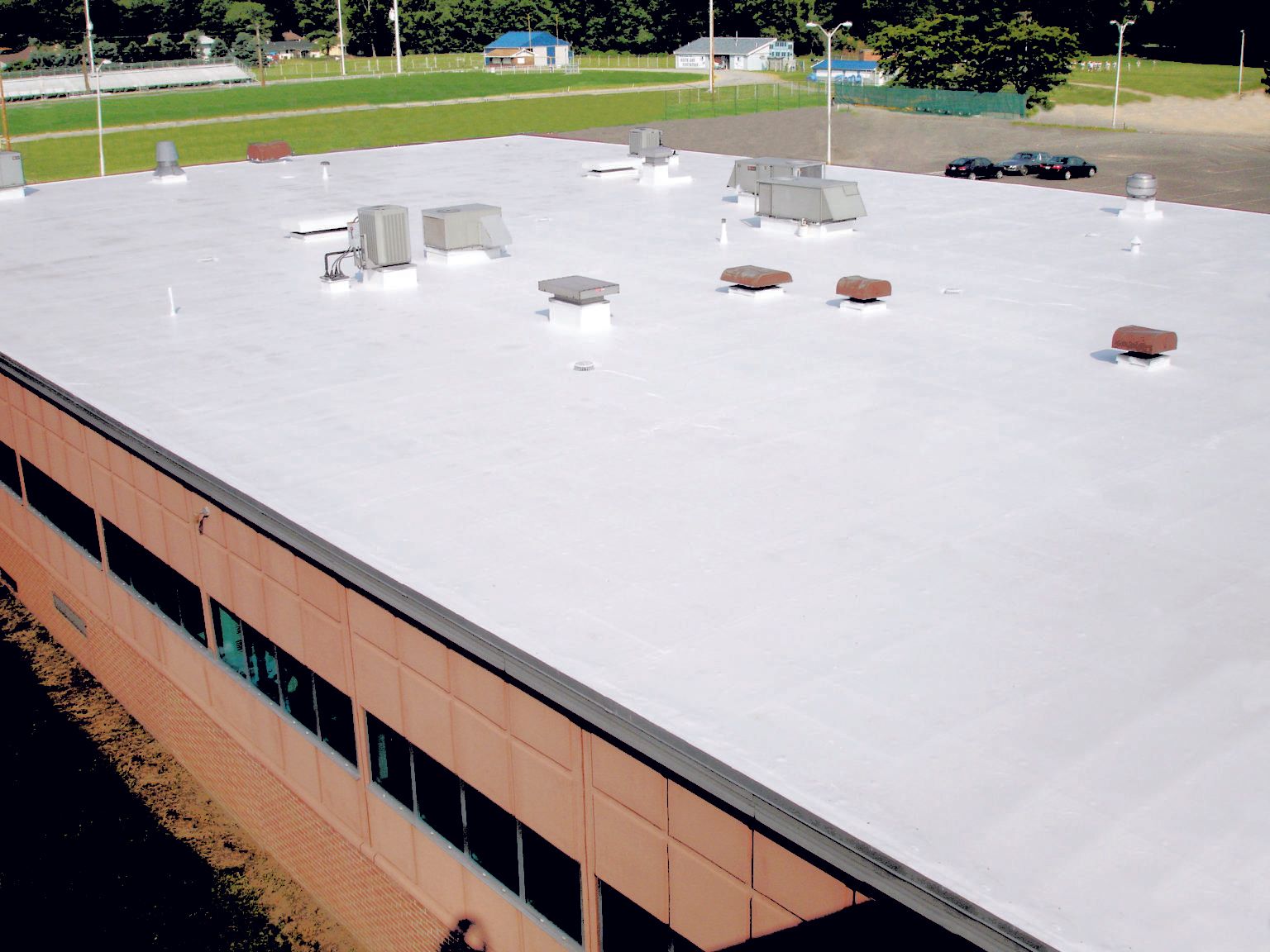 an aerial view of a building with a white roofing membrane coating
