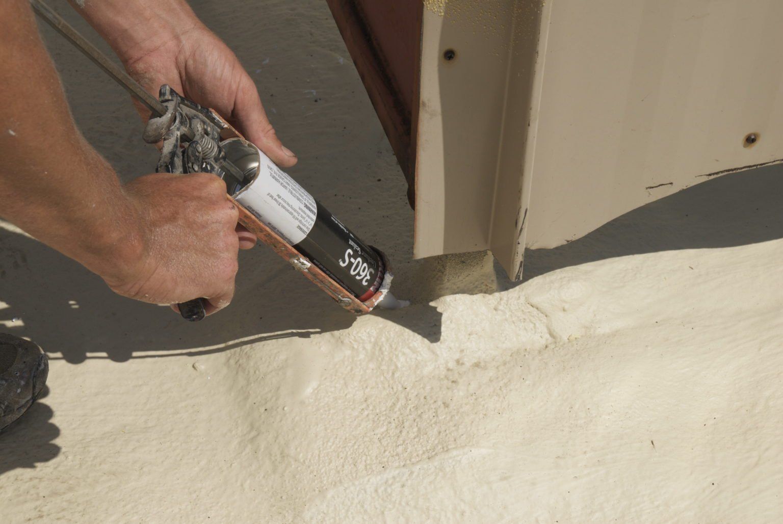 a person spraying roof insulation on a surface