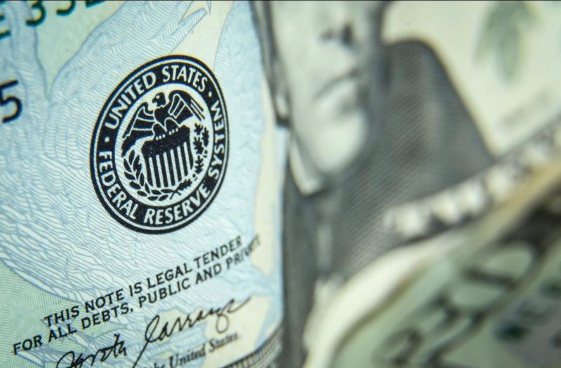 Close-up of US currency, with the Federal Reserve seal in focus.