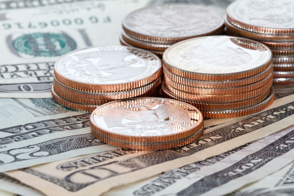 Stacks of coins and scattered US dollar bills.