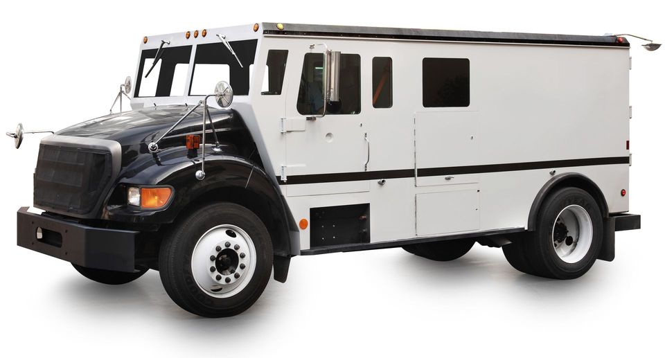 Armored truck, black cab, white cargo area, parked on white surface.