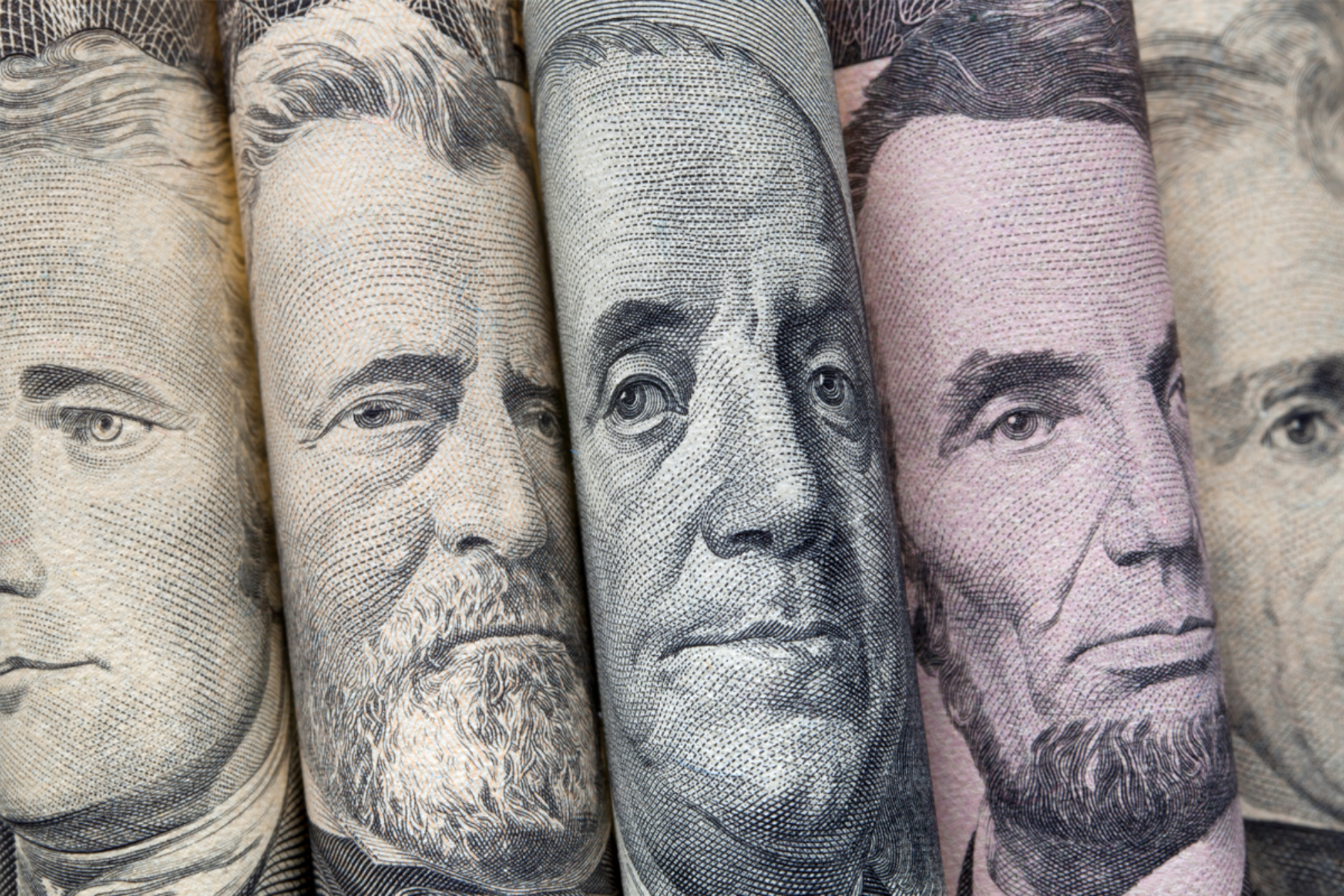 Pile of US twenty-dollar bills, green and white, on a white background.