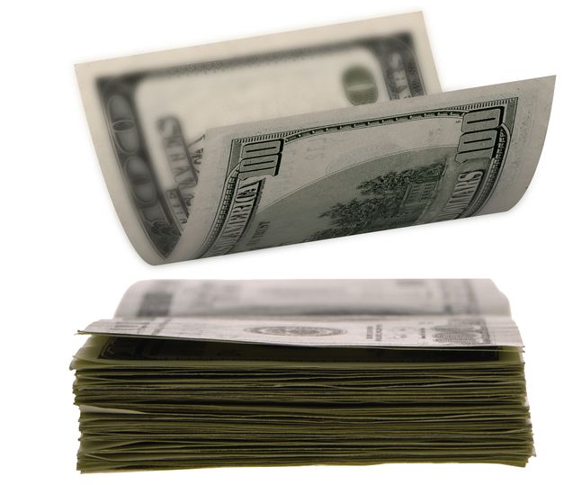 Stack of US hundred dollar bills with a bill being flipped open.