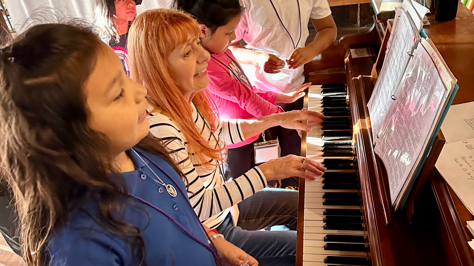A group of people are playing a piano together.