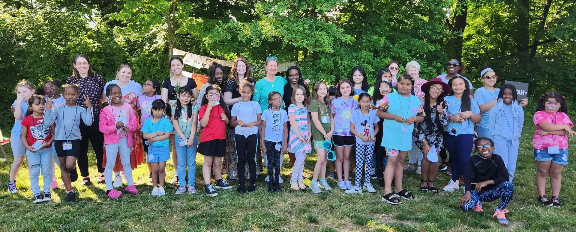 A large group of children are posing for a picture in a park.
