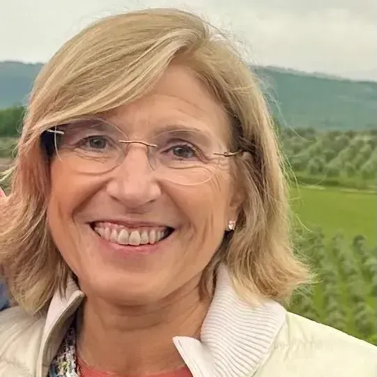 A close up of a woman wearing glasses and smiling.