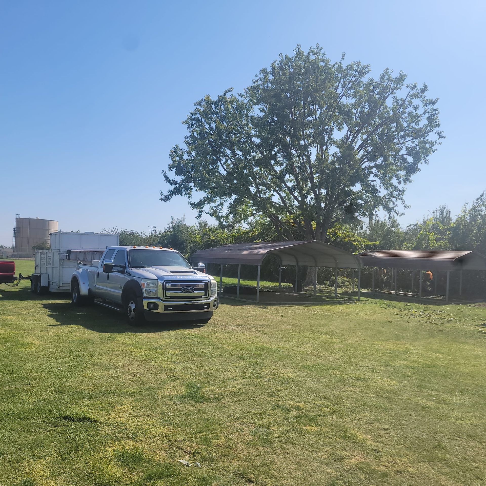 A truck and trailer are parked in a grassy field.