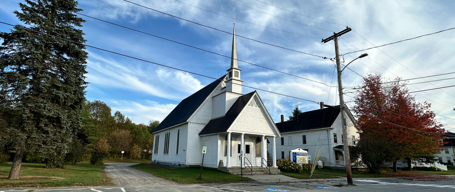 Lyndonville Methodist Church building with steeple under blue sky.