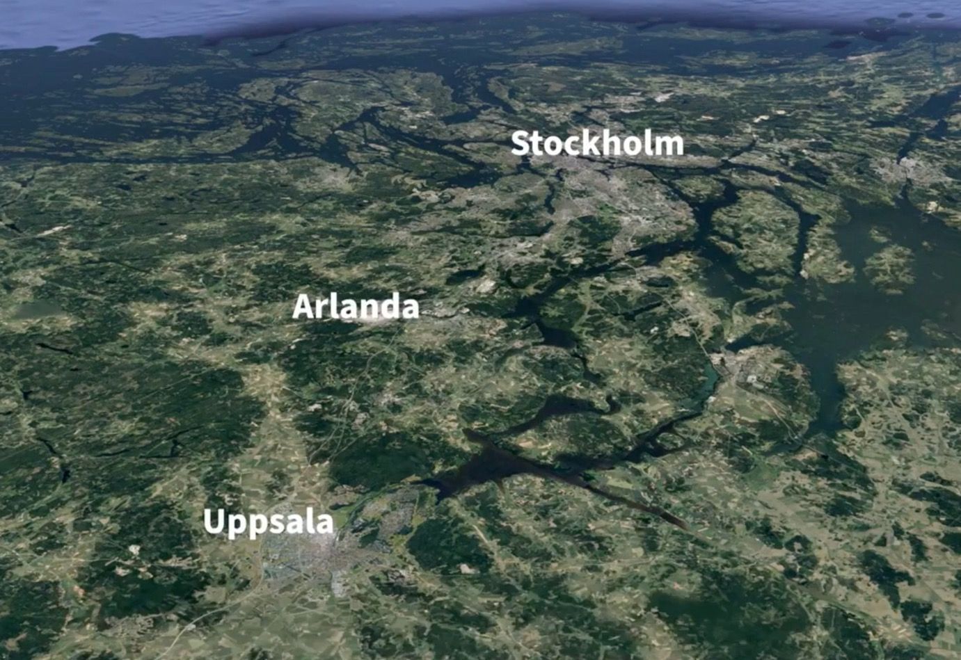 Aerial view of central Sweden with Stockholm, Uppsala, and Arlanda airport visible. Green land and blue waterways.