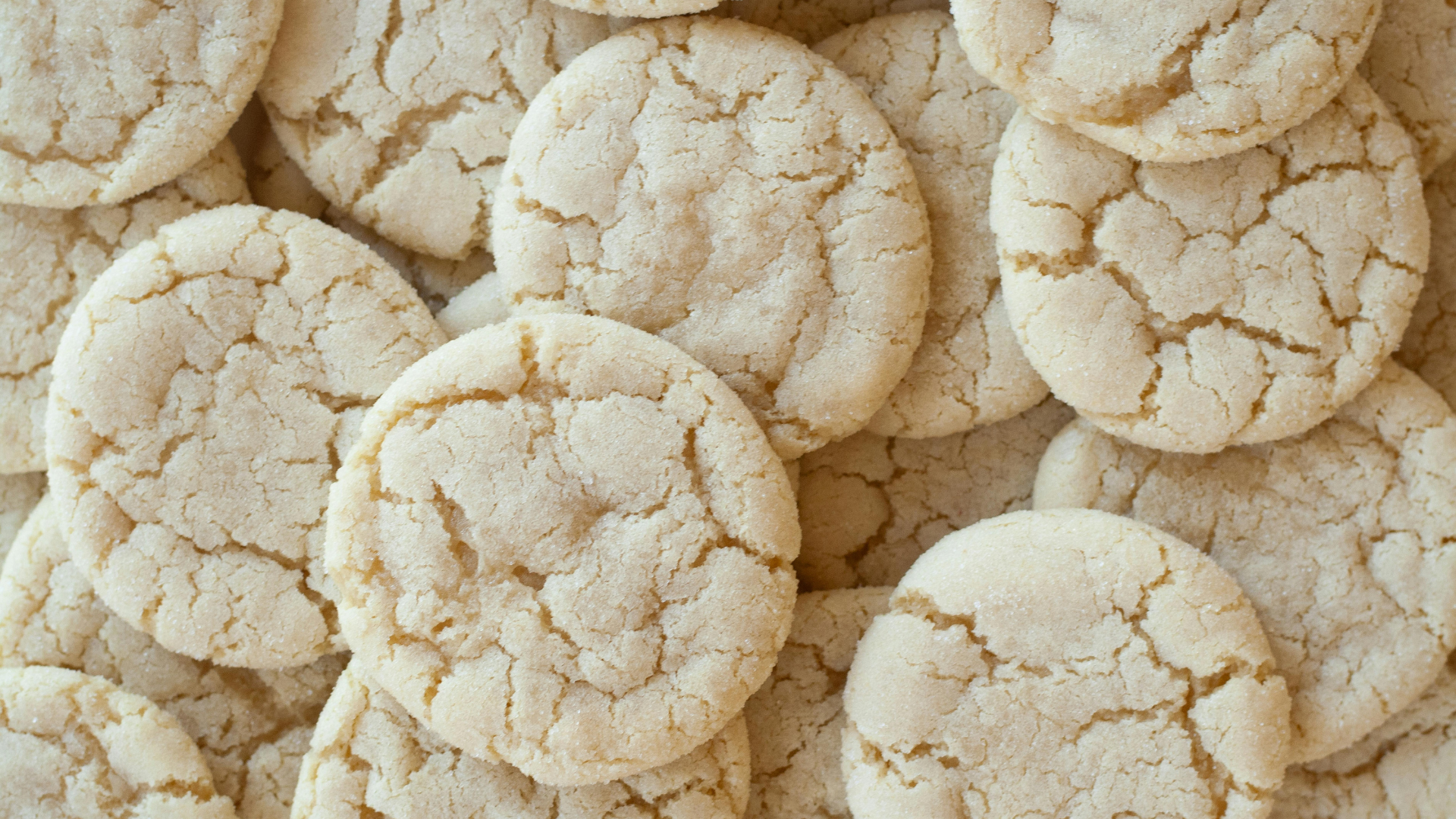 Overhead view of a pile of beige, crinkled sugar cookies.