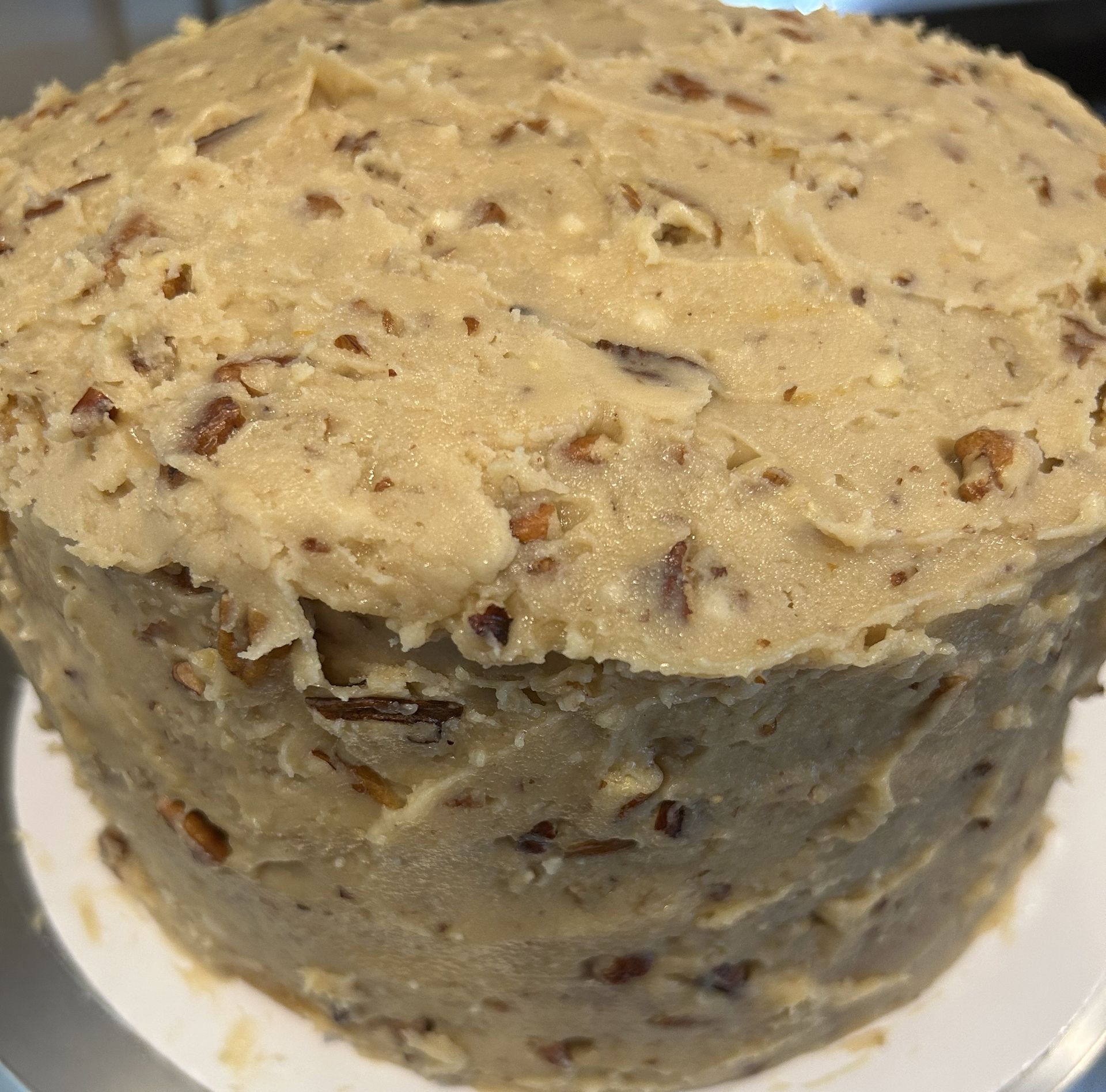 Cake frosted with light brown pecan frosting.
