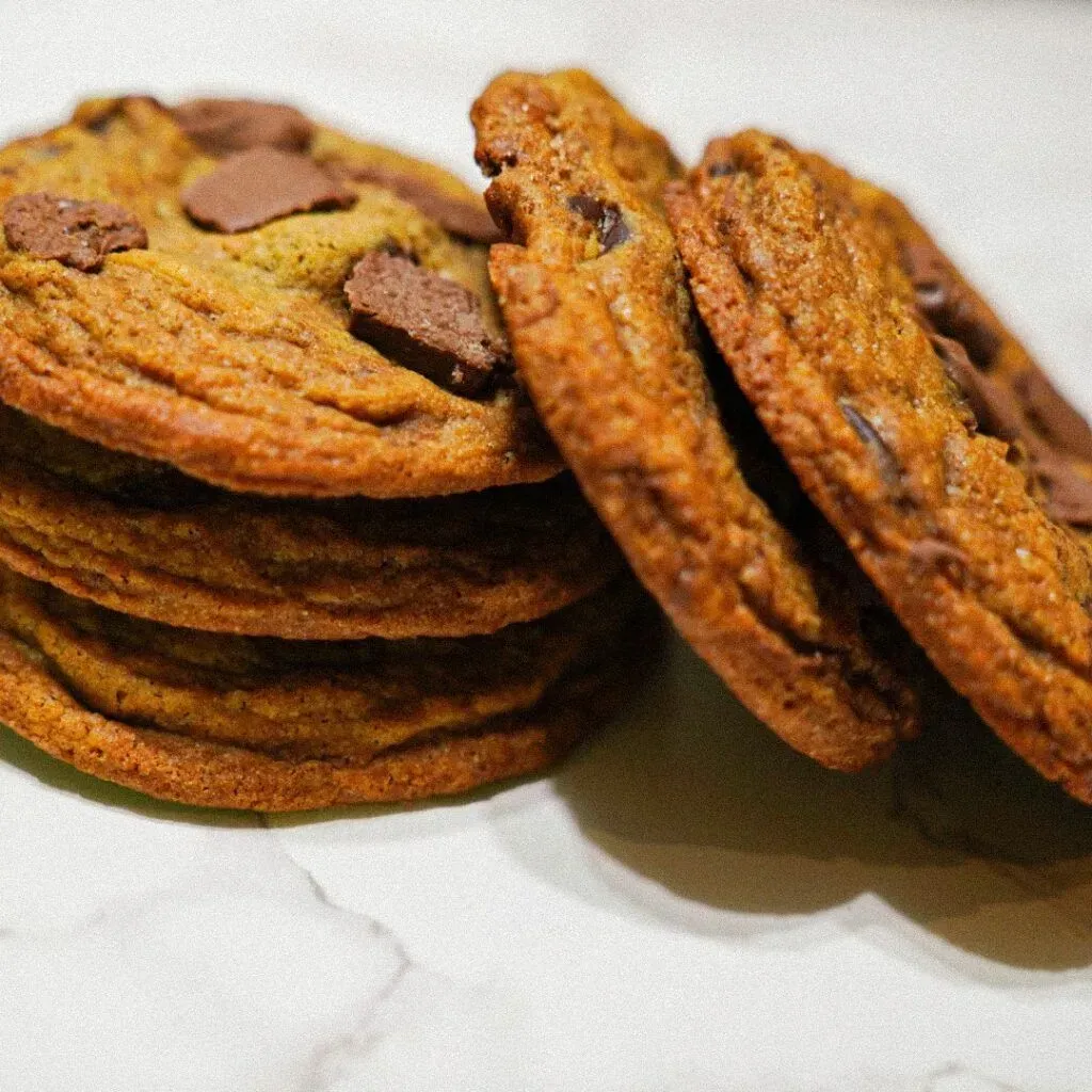 Stack of chocolate chip cookies with visible chunks of chocolate.