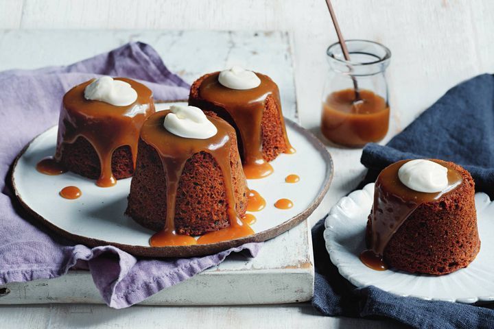 Sticky toffee puddings with caramel sauce and whipped cream.